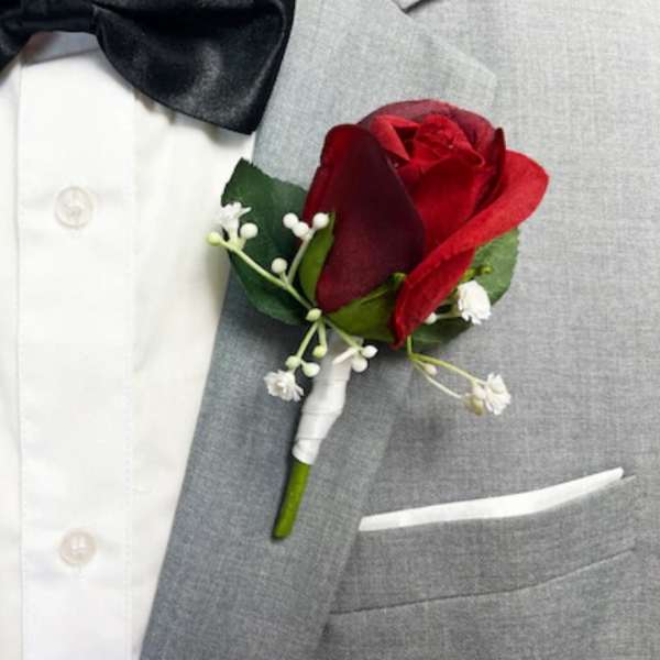 Red rose boutonniere on a gray suit jacket