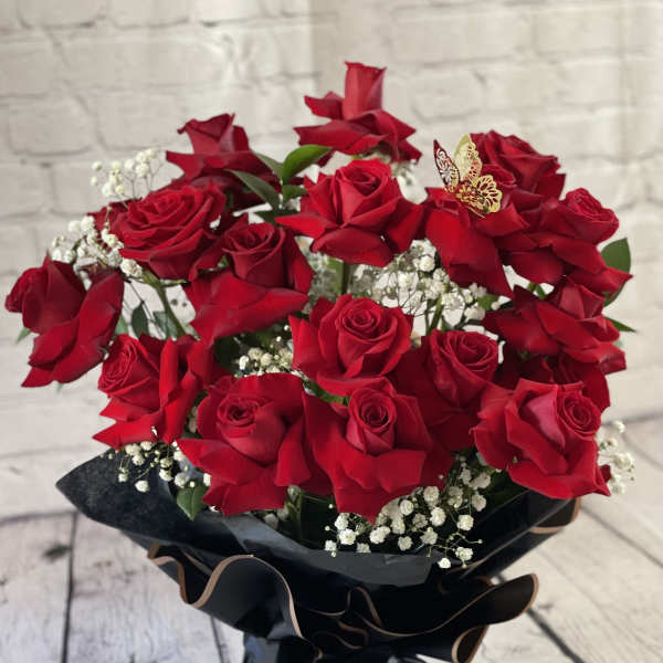 Bouquet of red roses with baby's breath in black wrap