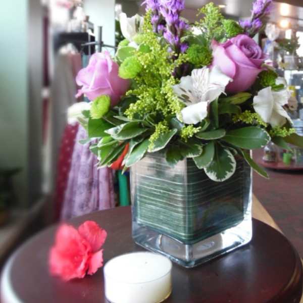 Pink and white flowers arranged in a square glass vase