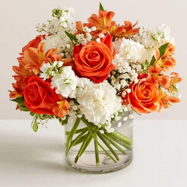 Orange and white bouquet in a clear glass vase