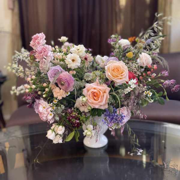 Mixed pastel bouquet in a white pedestal vase