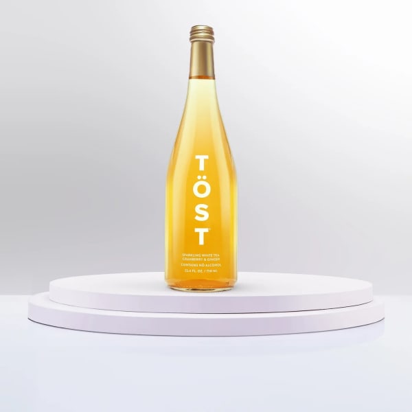 Bottle of sparkling white tea on a white pedestal