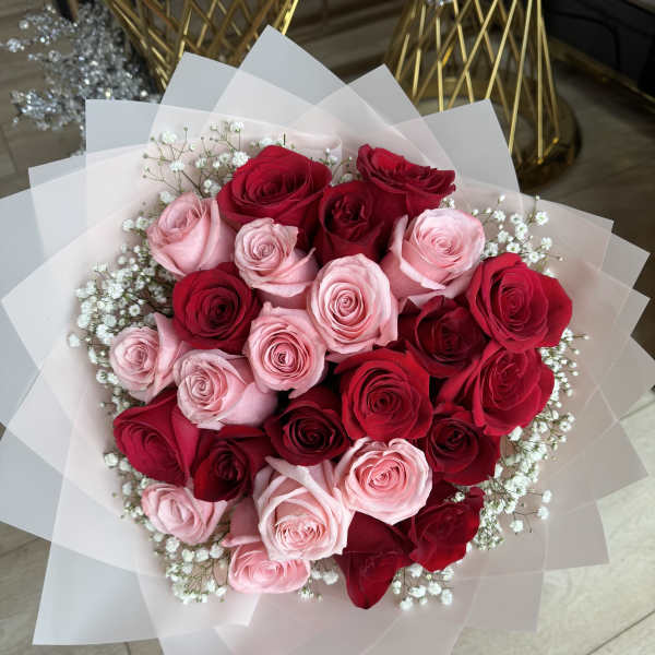 Bouquet of red and pink roses wrapped in white paper