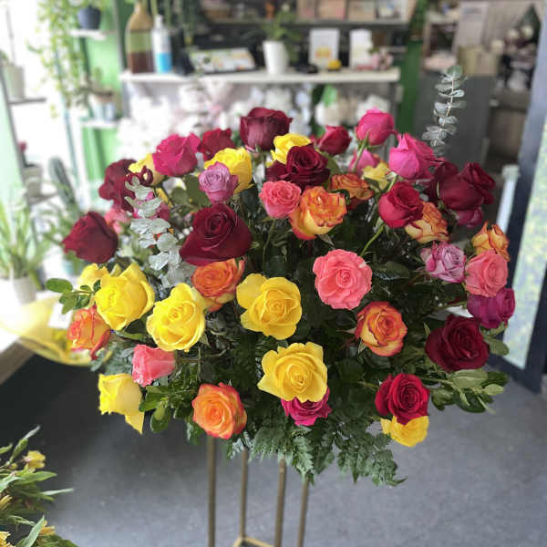 Large bouquet of multicolored roses on a tall stand
