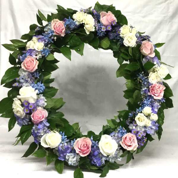 Circular floral wreath with pink and white roses and purple flowers