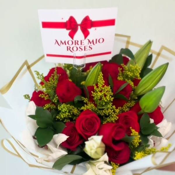 Bouquet of red and white roses with a red ribbon and card