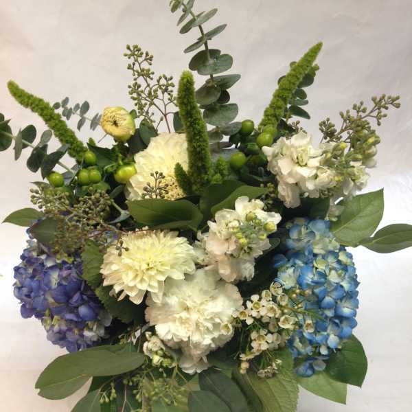 Mixed bouquet with blue, purple, and white hydrangeas and greenery
