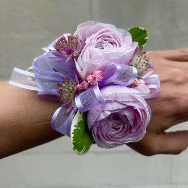 Lavender wrist corsage with ribbon and small pink flowers