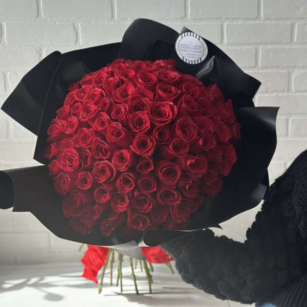 Large bouquet of red roses wrapped in black paper