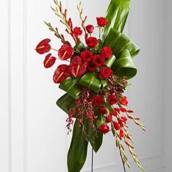Tall red floral arrangement with large green leaves