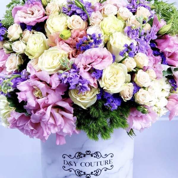 Large pastel bouquet of roses and purple blooms in a white hat box