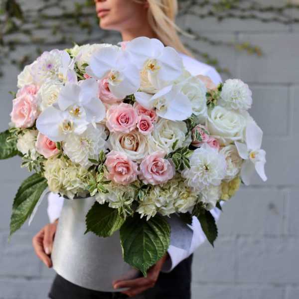 Large bouquet of white orchids, pink roses, and white blooms in a silver box