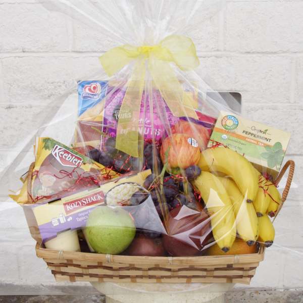 Gift basket with fruit and packaged snacks wrapped in clear cellophane