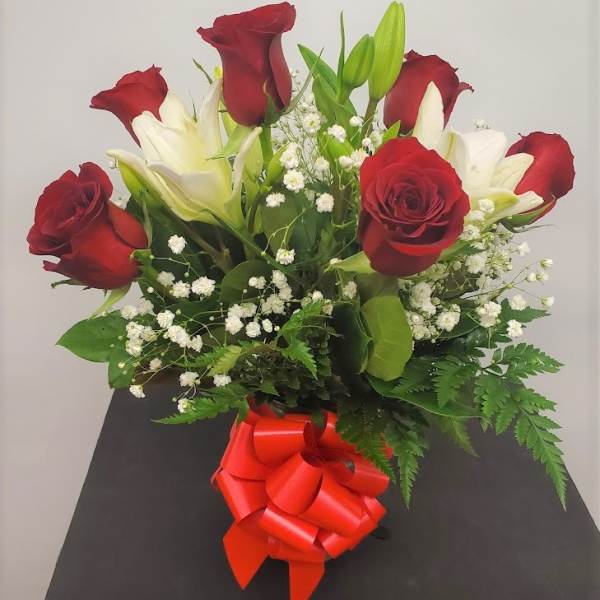 Bouquet of red roses and white lilies with a red ribbon bow