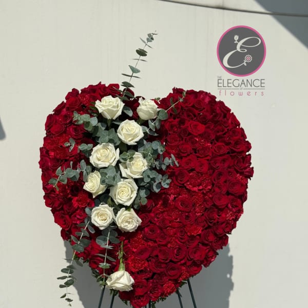 Heart-shaped red and white rose arrangement on a stand