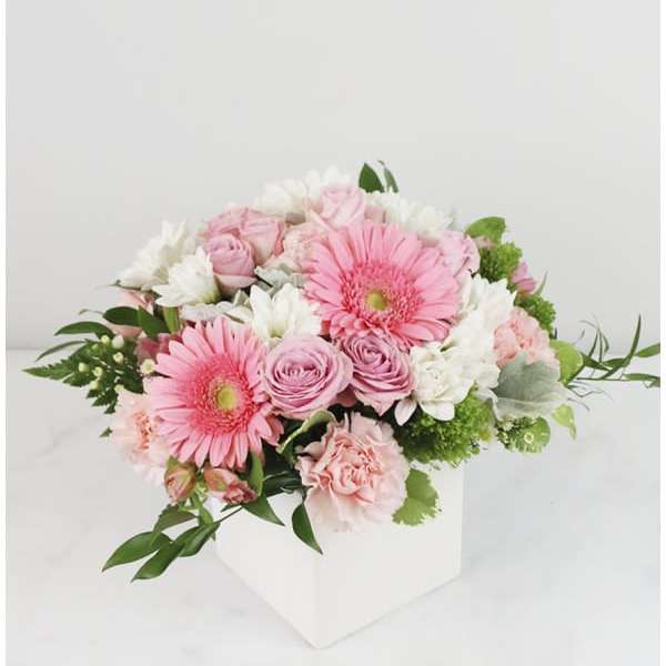 Pink and white bouquet in a white box vase