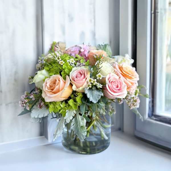 Bouquet of pastel roses in a clear glass vase