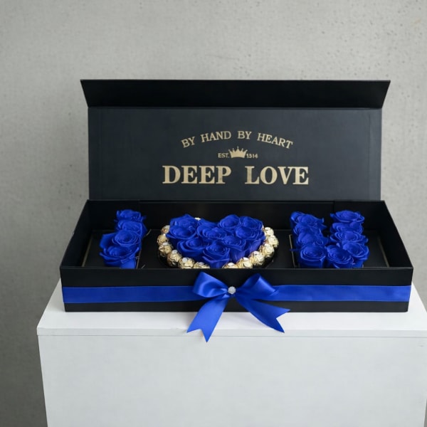 Blue roses arranged in a black gift box with a ribbon bow