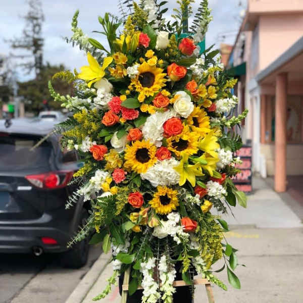 Yellow, orange & white sympathy spray.