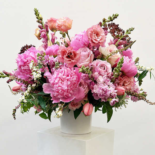 Pink mixed flower arrangement in a white vase