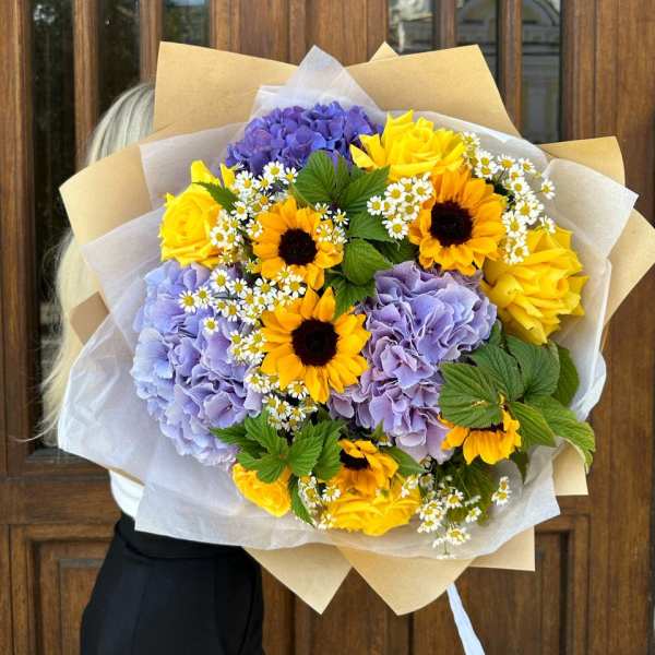 Bouquet of yellow sunflowers, purple hydrangeas, and small white daisies