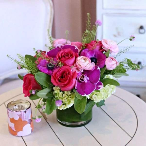 Pink and purple floral arrangement in a glass vase on a table