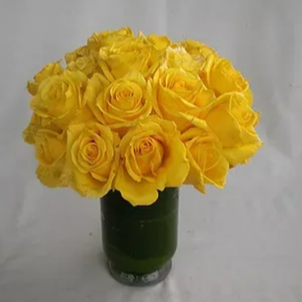 Yellow roses arranged in a green glass vase