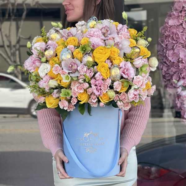 Large bouquet of pink and yellow roses in a blue box
