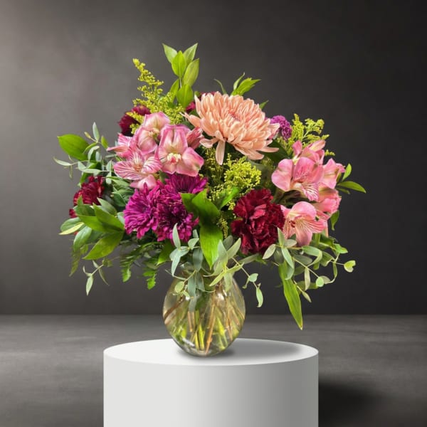 Mixed pink and purple flowers in a clear glass vase