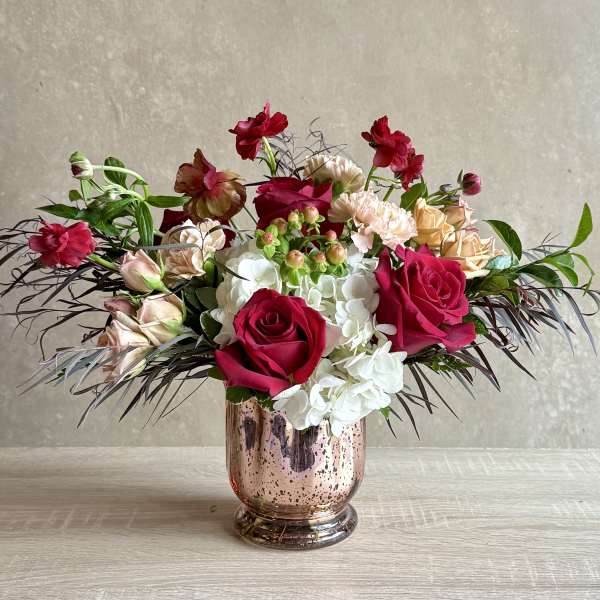 Mixed bouquet of roses and hydrangeas in a metallic vase