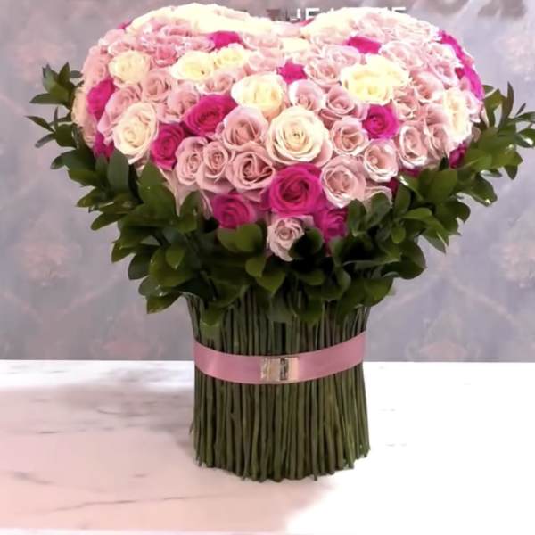 Large bouquet of pink and white roses with a pink ribbon wrap