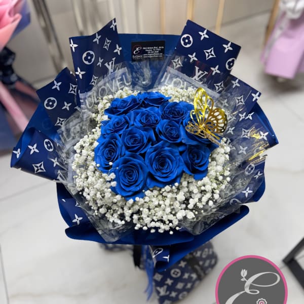Bouquet of vivid blue roses with white baby's breath and a gold butterfly accent