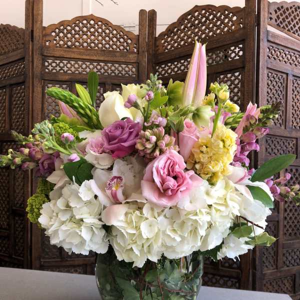 Pink and white mixed flower arrangement in a glass vase