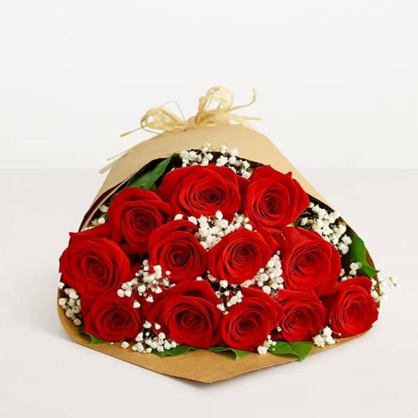 Bouquet of red roses with white baby's breath in brown paper wrap