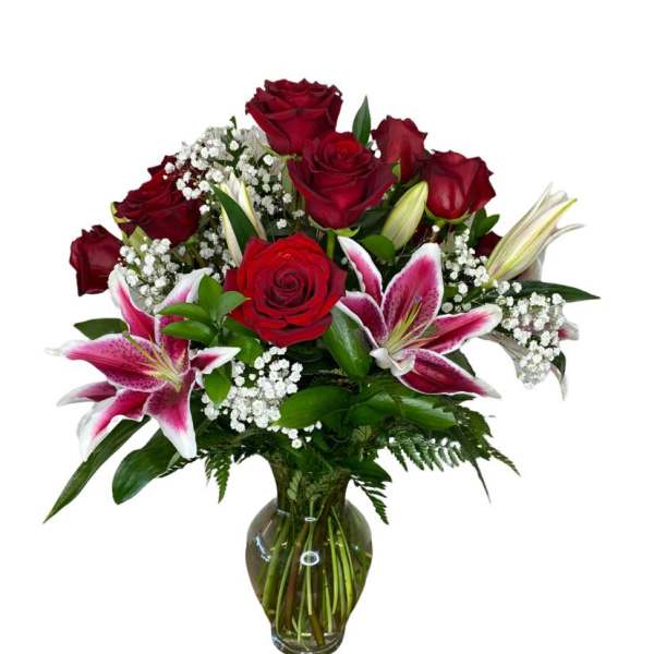 Red roses and pink lilies arranged in a glass vase