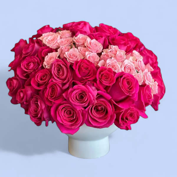 Bouquet of pink and hot pink roses in a white vase