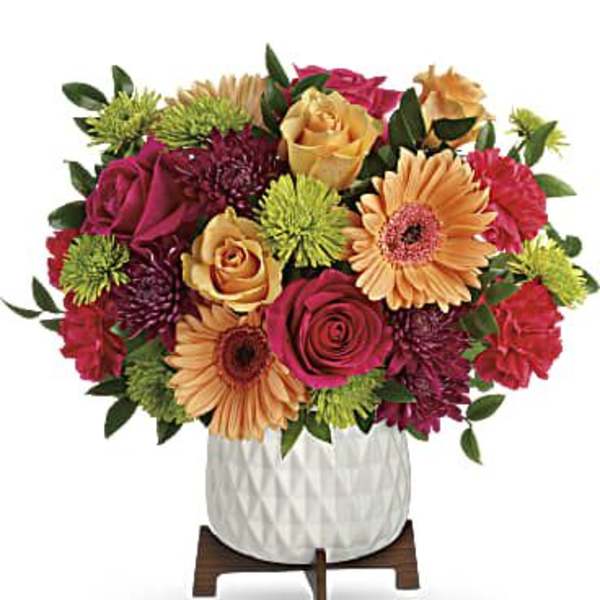 Mixed bouquet of roses, gerbera daisies, and chrysanthemums in a white vase