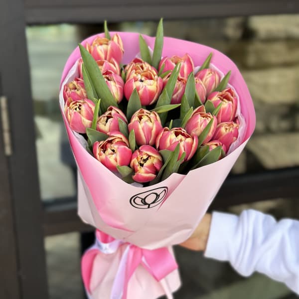 Bouquet of pink tulips wrapped in pink paper with a ribbon