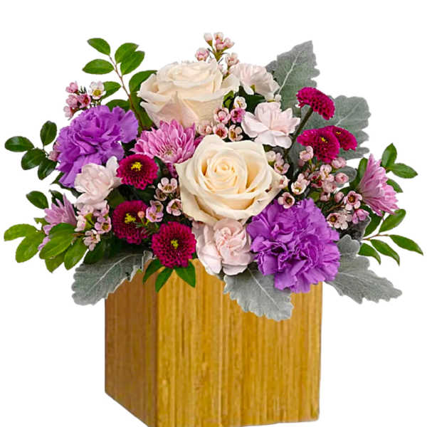 Bouquet of cream, pink, and purple flowers in a wooden cube vase