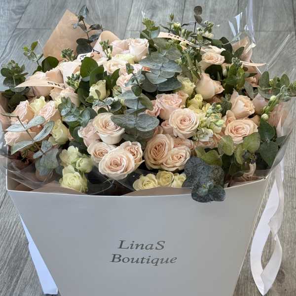 Bouquet of pale pink roses and eucalyptus in a white box