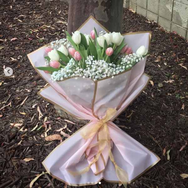 Bouquet of pink and white tulips wrapped in pink paper
