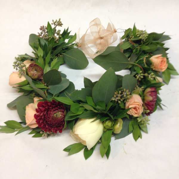 Floral wreath with peach and burgundy blooms and a sheer ribbon bow