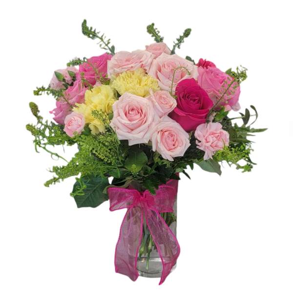 Pink and yellow rose bouquet in a glass vase with a magenta ribbon