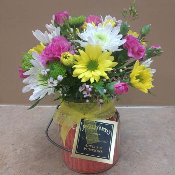 Mixed bouquet in a candle jar with a yellow ribbon