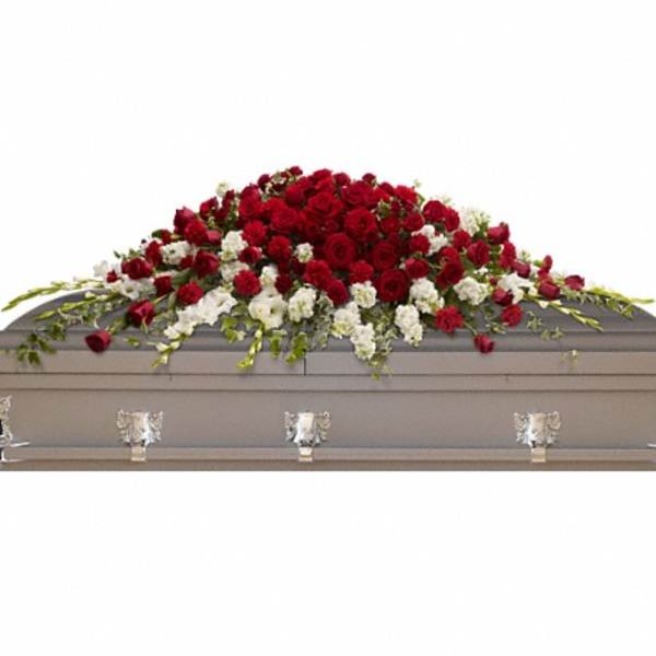 Red and white floral casket spray on a gray casket