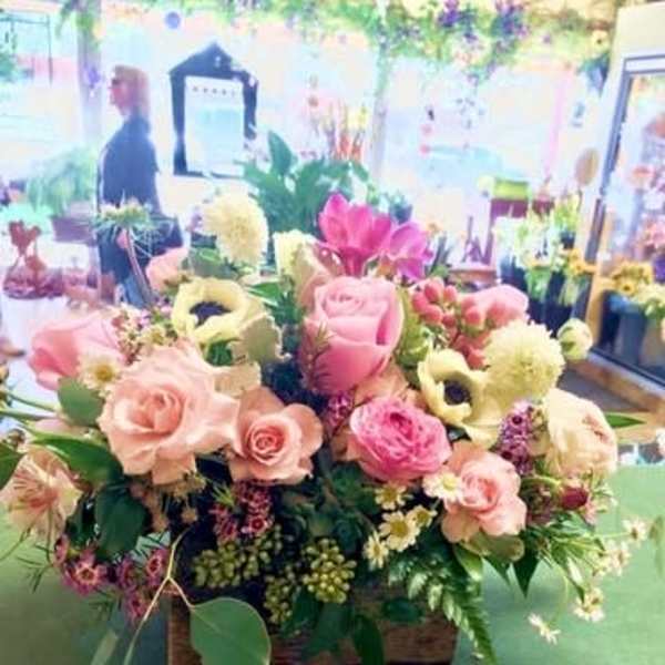 Mixed pink and cream flower arrangement in a basket
