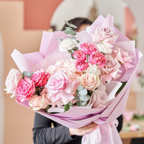 Pink and white rose bouquet wrapped in pastel paper