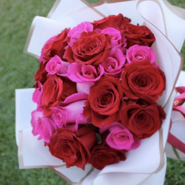 Bouquet of red and pink roses wrapped in white paper