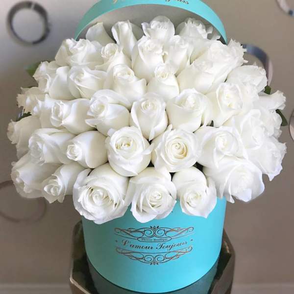 Bouquet of white roses in a turquoise hatbox