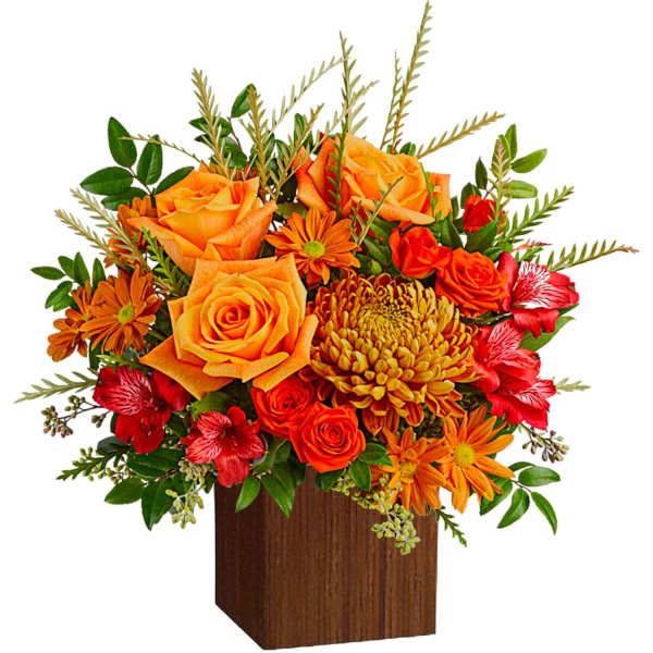 Orange and red floral arrangement in a wooden cube vase